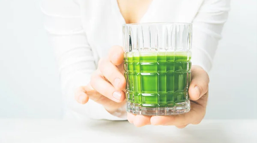 Close view of woman holding glass with Chlorella
