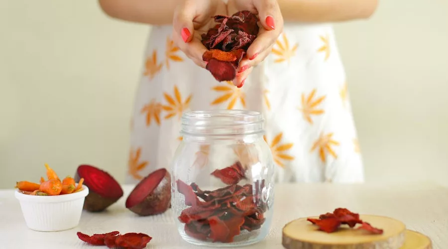 Hands of a Woman Holding Dried Beetroot Chips
