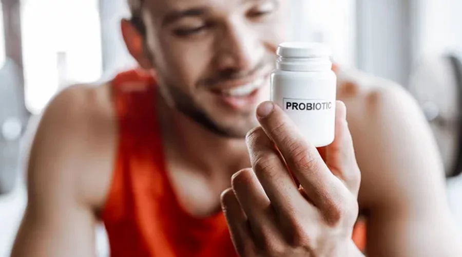 Sportsman holding bottle with probiotics